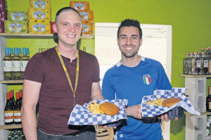 Two medical students showing their gourmet burgers and fries.