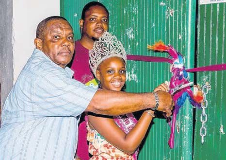 Commissioner of Culture Rolando Wilson (left) is assisted by Saba Festival Foundation President Vito Charles and Little Miss Saba Meliegqia Hughes in officially opening the gates to the Carnival Village. (STK photo)